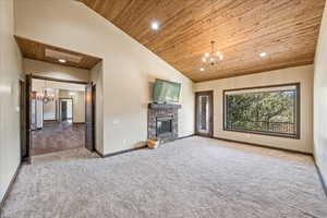 Unfurnished living room featuring a chandelier, wooden ceiling, and high vaulted ceiling