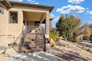 Doorway to property featuring stone siding and stucco siding