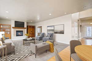 Living area with baseboards, light wood finished floors, a fireplace, and recessed lighting