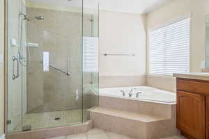 Bathroom with a bath, a shower stall, vanity, and tile patterned floors