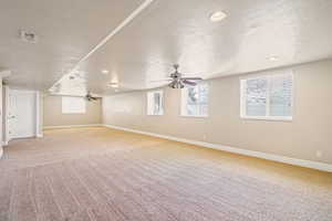 Spare room with a ceiling fan, carpet flooring, a textured ceiling, and baseboards