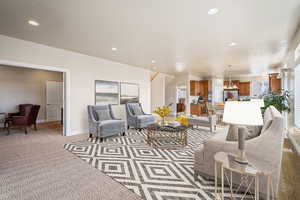 Living area with light carpet, baseboards, and recessed lighting