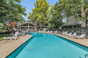 Pool with a patio area and fence