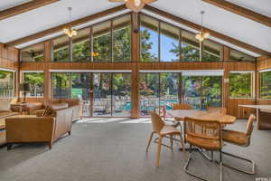 Interior space featuring vaulted ceiling with beams and a chandelier