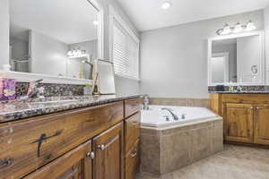 Bathroom with two vanities, a sink, a shower stall, tile patterned flooring, and a bath