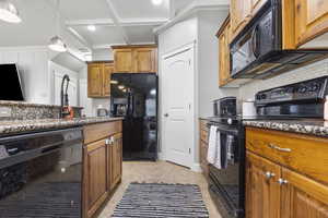 Kitchen featuring black appliances, brown cabinets, backsplash, and coffered ceiling