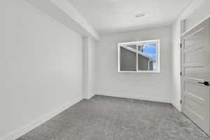 Carpeted empty room featuring visible vents and baseboards