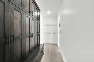 Mudroom featuring baseboards and light wood-style floors