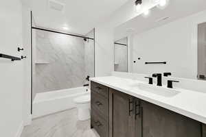 Bathroom with marble finish floor, visible vents, toilet, vanity, and shower / tub combination