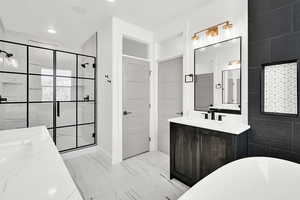 Bathroom featuring marble finish floor, a shower stall, two vanities, and a sink