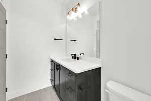 Bathroom with toilet, baseboards, and vanity