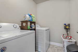 Clothes washing area featuring baseboards, laundry area, and washer and dryer