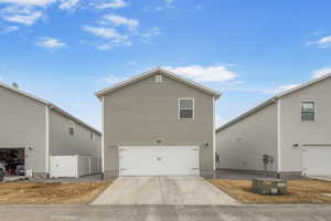 View of side of home with driveway and an attached garage