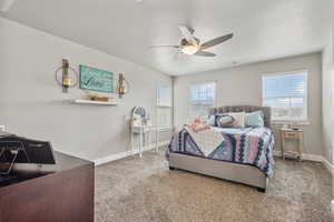 Bedroom featuring visible vents, baseboards, ceiling fan, carpet, and a textured ceiling