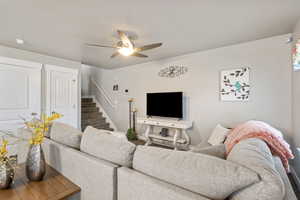 Living room with stairs and a ceiling fan