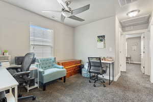 Carpeted office space with ceiling fan, attic access, visible vents, and baseboards