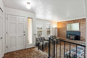 Carpeted foyer featuring a textured ceiling