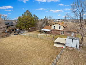 View of yard with a storage shed, an outdoor structure, and fence