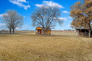 View of yard featuring an exterior structure, an outbuilding, and a rural view