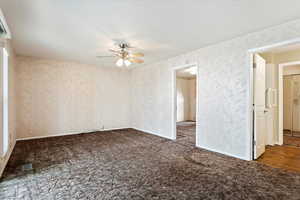 Carpeted spare room featuring visible vents, ceiling fan, and baseboards