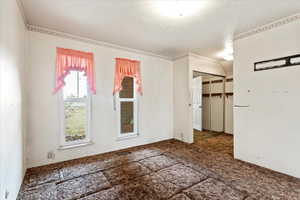 Unfurnished room featuring visible vents and a textured ceiling