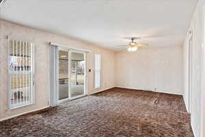 Carpeted spare room featuring a textured ceiling, a ceiling fan, and baseboards