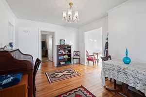 Dining area featuring ornamental molding, an inviting chandelier, and hardwood / wood-style floors