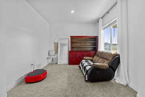 Sitting room with carpet, visible vents, and baseboards