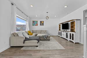 Living area featuring baseboards, wood finished floors, and recessed lighting