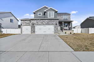 View of front of home featuring driveway, an attached garage, fence, a porch, and a front yard