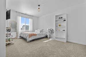 Bedroom featuring carpet, visible vents, a textured ceiling, and baseboards