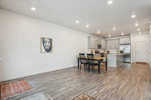 Dining area with light wood finished floors, baseboards, and recessed lighting