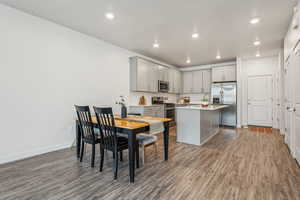 Dining space with baseboards, wood finished floors, and recessed lighting
