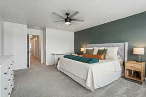 Bedroom with carpet flooring, a textured ceiling, baseboards, visible vents, and ceiling fan
