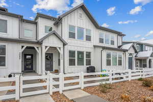 View of front of home with a fenced front yard and board and batten siding