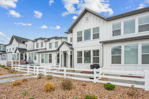 View of front of property with board and batten siding and a fenced front yard