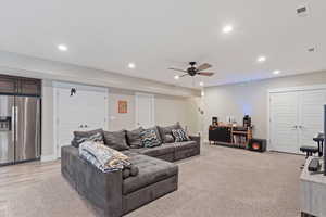 Living area featuring light carpet, a ceiling fan, visible vents, and recessed lighting