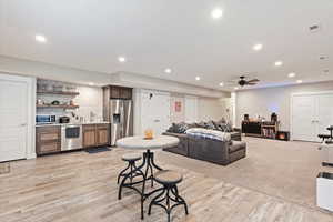 Living room with recessed lighting, visible vents, and light wood finished floors