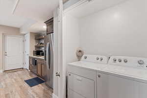 Laundry room featuring light wood-style floors and independent washer and dryer