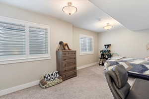 Bedroom featuring light carpet and baseboards