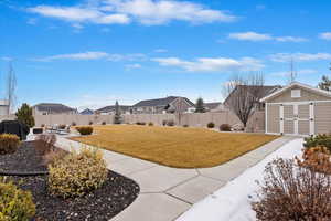 View of yard with an outbuilding, a fenced backyard, a residential view, a shed, and a patio area