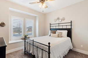 Bedroom featuring carpet, a ceiling fan, and baseboards