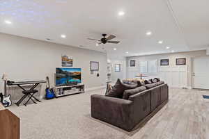 Living area with light wood-style floors, recessed lighting, visible vents, and ceiling fan