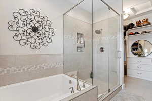 Bathroom featuring a shower stall, a bath, and tile patterned floors