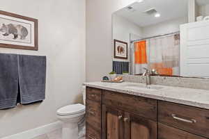 Full bath featuring toilet, tile patterned flooring, visible vents, and vanity