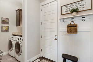 Laundry area with cabinet space, visible vents, baseboards, and separate washer and dryer