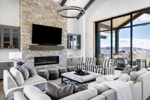 Living area featuring high vaulted ceiling, beamed ceiling, a fireplace, and wood finished floors