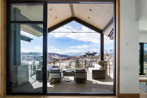 Snow covered back of property featuring an outdoor living space and a mountain view