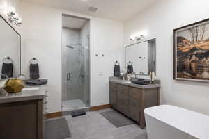 Full bathroom with a stall shower, visible vents, a soaking tub, tile patterned floors, and two vanities