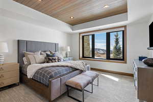 Bedroom featuring light carpet, baseboards, wooden ceiling, a tray ceiling, and recessed lighting